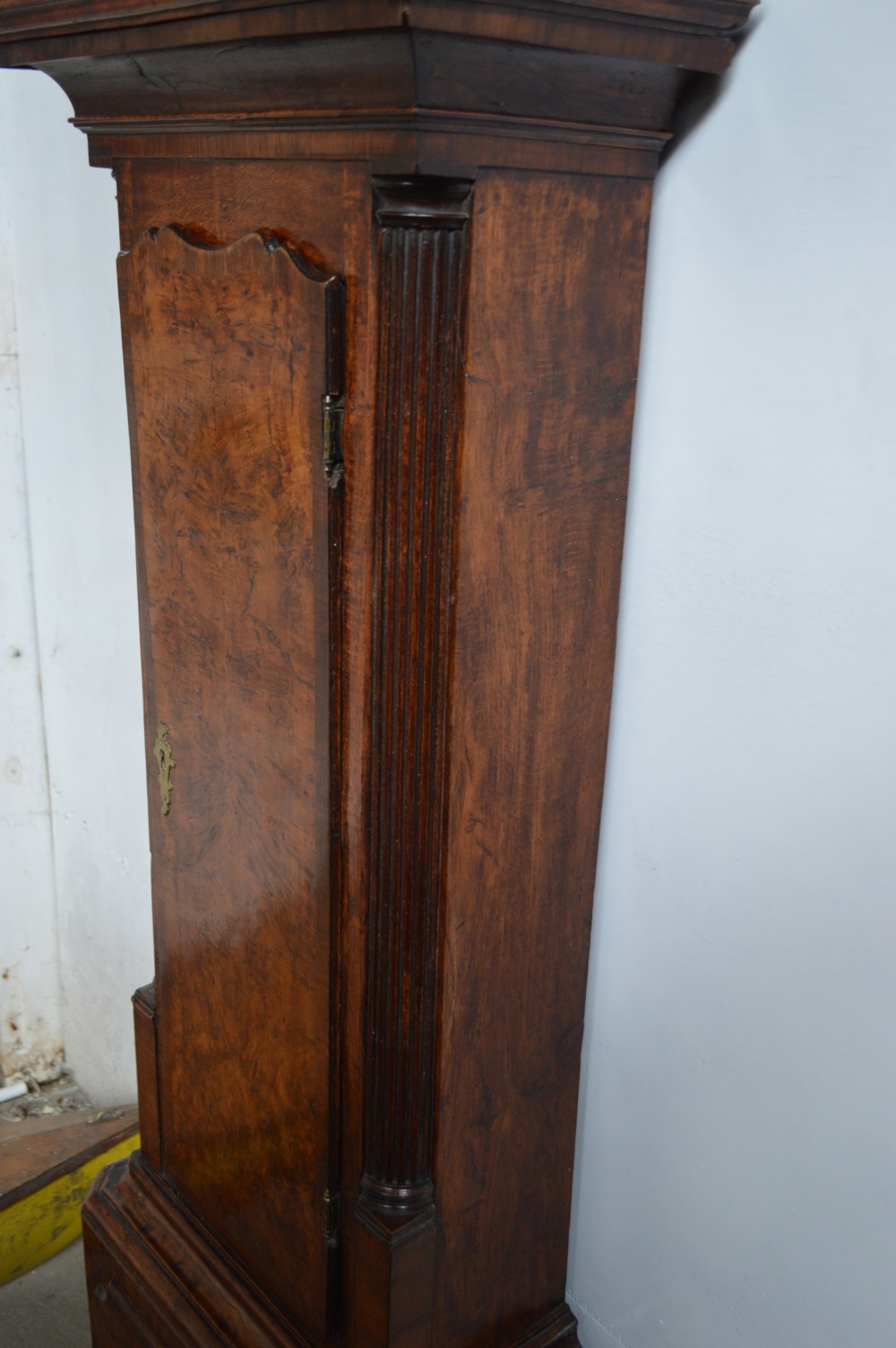 An 18th-century pollard oak longcase clock with an arched hood, brass eagle finial, and engraved brass dial. View VIII