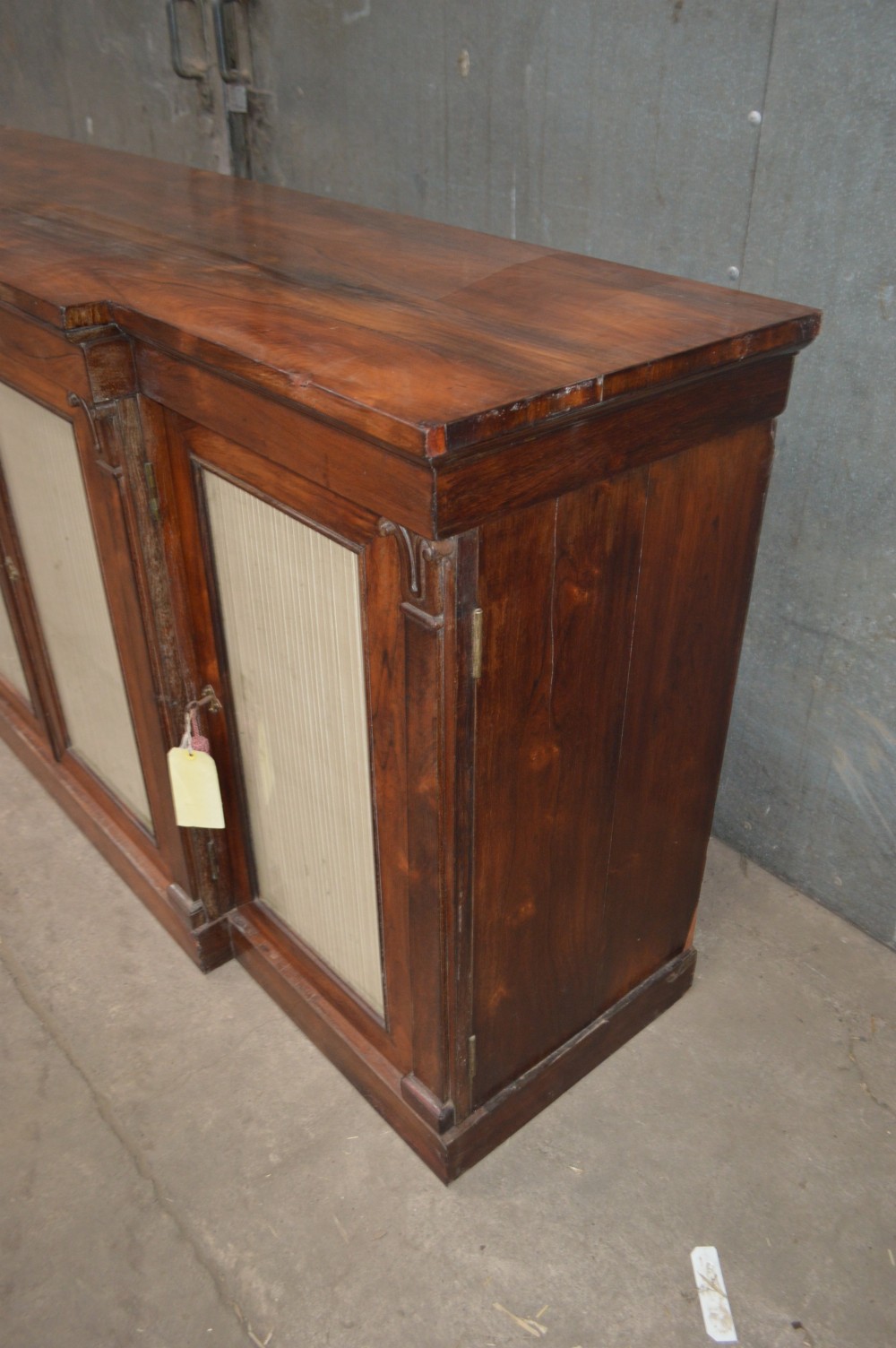 A Regency rosewood breakfront cabinet featuring four doors with pleated fabric panels and carved pilasters. View III