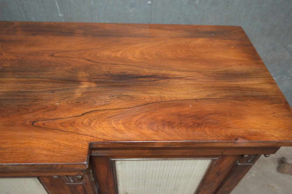 A Regency rosewood breakfront cabinet featuring four doors with pleated fabric panels and carved pilasters. View VIII