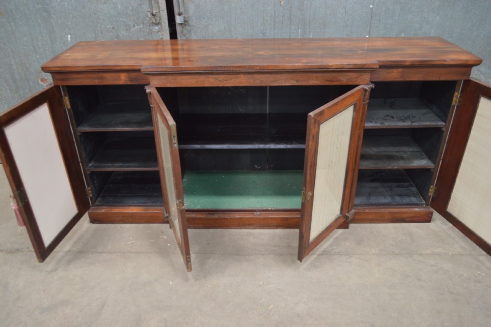 A Regency rosewood breakfront cabinet featuring four doors with pleated fabric panels and carved pilasters. View XI