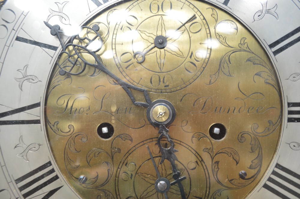 A tall Georgian mahogany longcase clock featuring an arched hood, a brass and spandrel dial with a moon phase disk, and an inlaid central door. View III