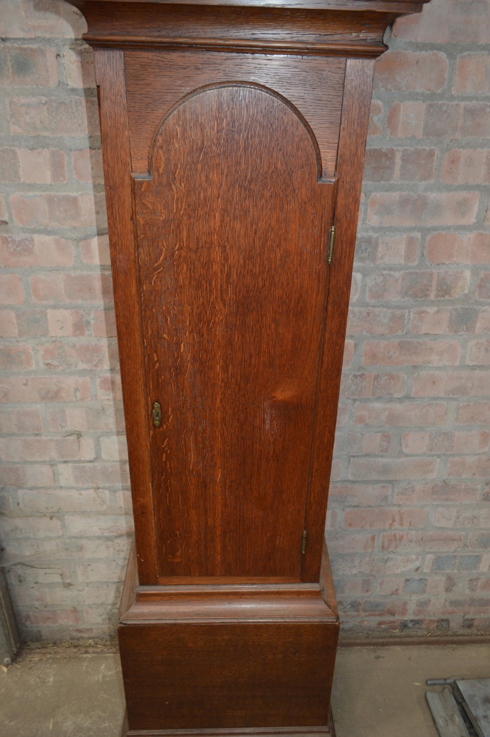 A late Victorian Scottish oak longcase clock with an arched hood, carved finials, and an arched painted dial. View V