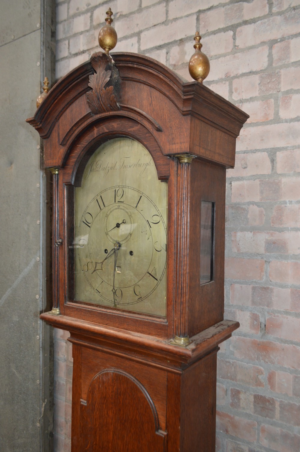 A late Victorian Scottish oak longcase clock with an arched hood, carved finials, and an arched painted dial. View VII