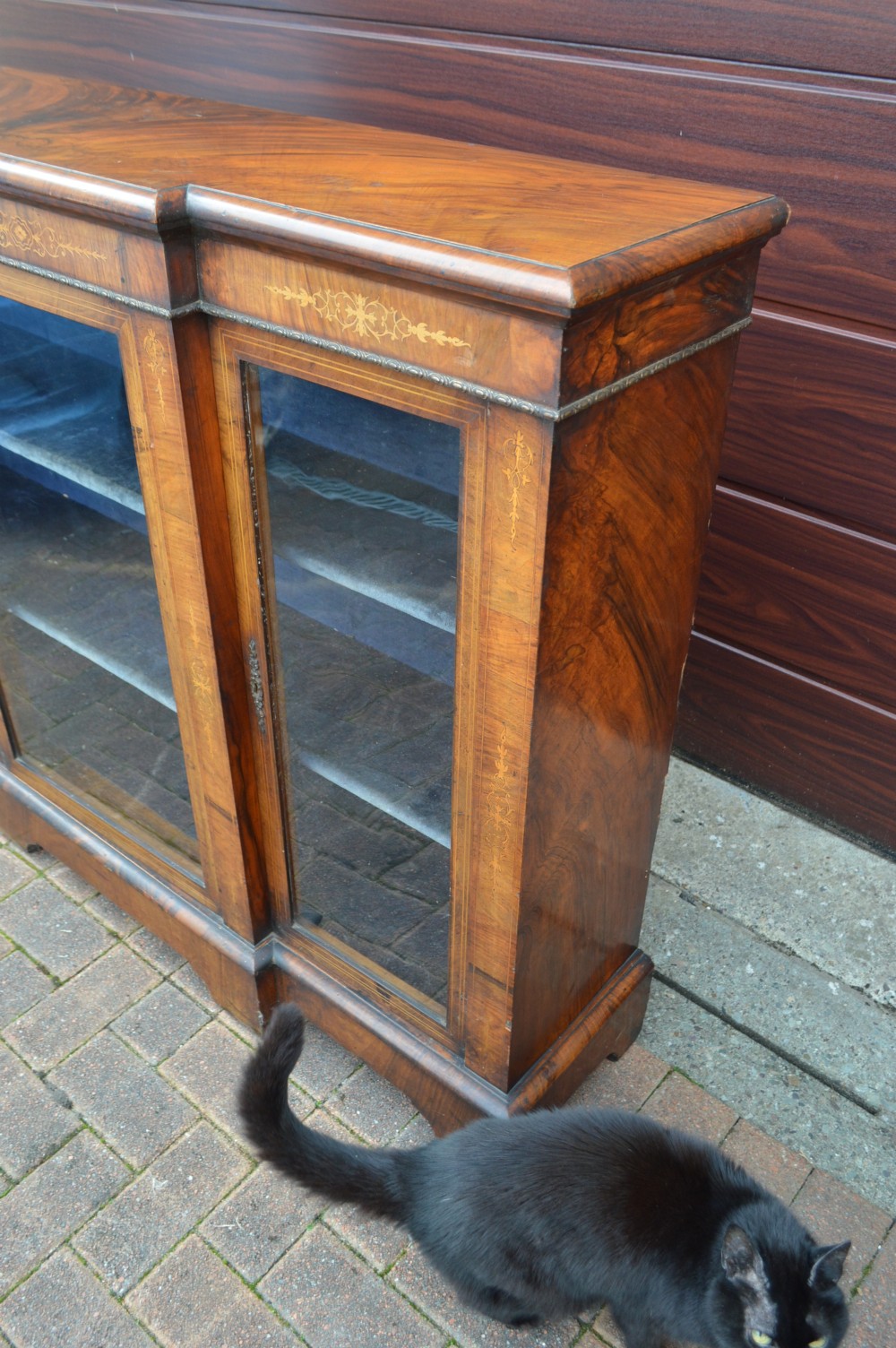 A low Victorian burr walnut breakfront bookcase featuring three glazed doors with floral marquetry inlays and decorative metal escutcheons. View III