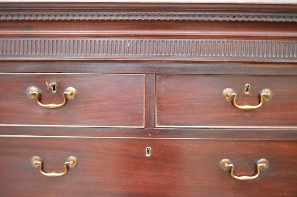 A tall Georgian mahogany chest on chest featuring two short over six long drawers with brass swan-neck handles and a dentil corniced top. View V