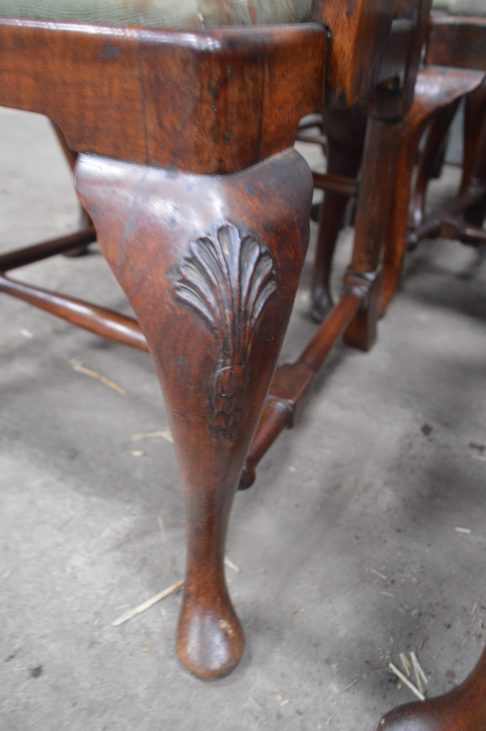 A set of George II burr walnut dining chairs featuring shaped vasiform back splats, upholstered drop-in seats, and cabriole legs. View V