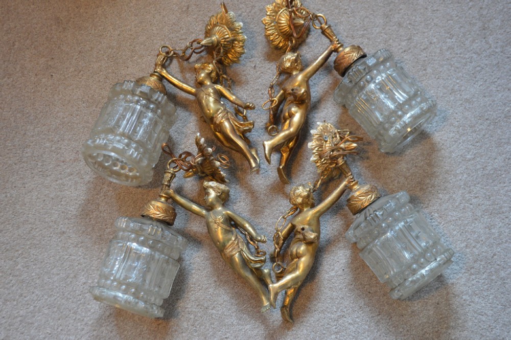 A nineteenth-century gilt metal chandelier featuring a central winged cherub supporting a column above five scrolling candelabra arms. View VI