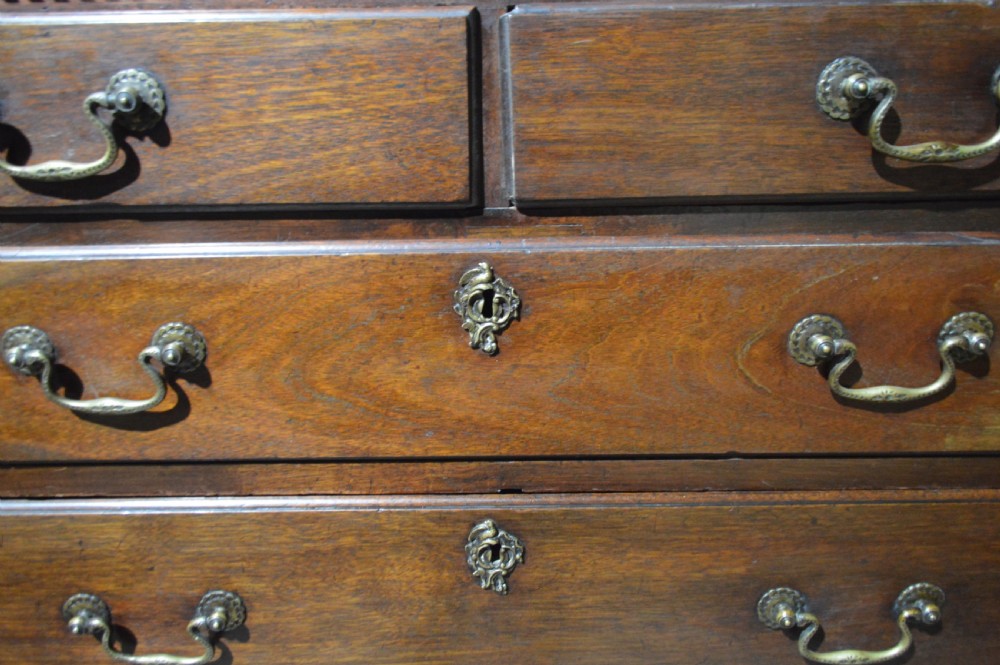 An antique Georgian mahogany chest-on-chest with brass swan-neck handles, keyhole escutcheons, and bracket feet. View II