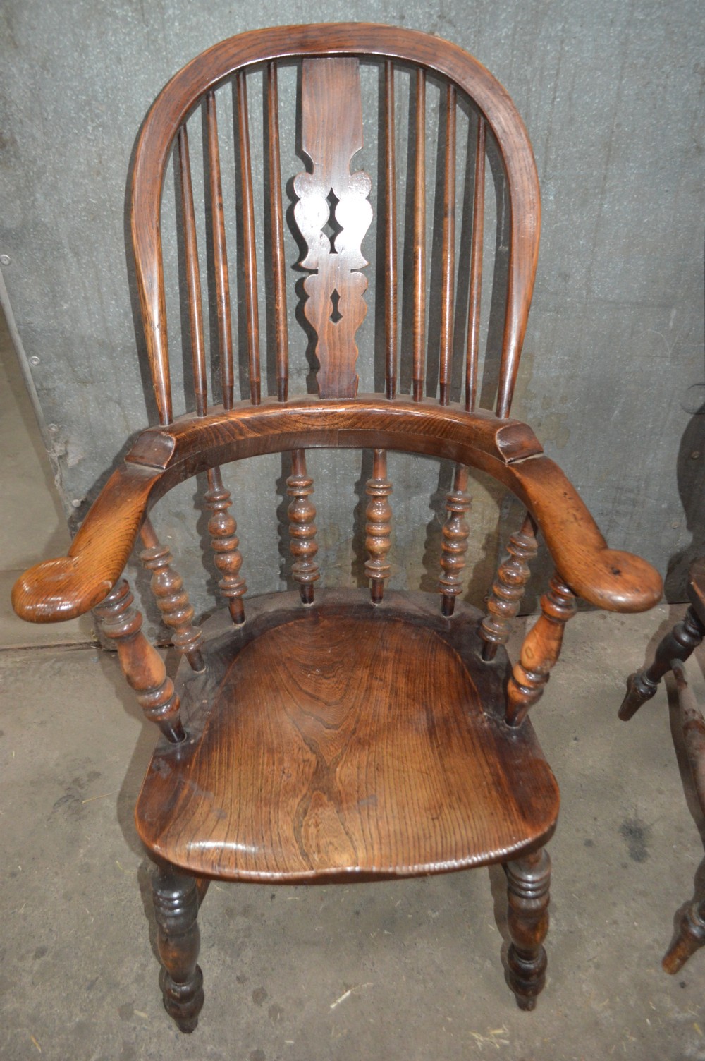 A set of six Victorian wooden Windsor armchairs featuring high hoop backs, central decorative splats, pad arms, and turned legs. View III