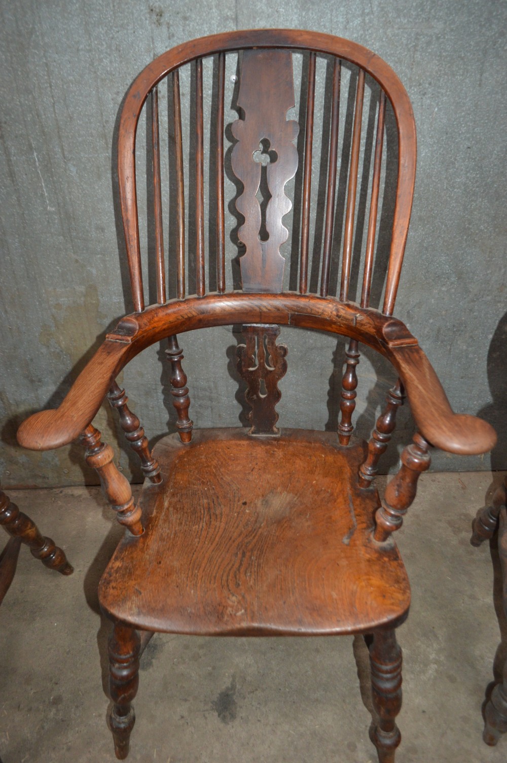 A set of six Victorian wooden Windsor armchairs featuring high hoop backs, central decorative splats, pad arms, and turned legs. View IV