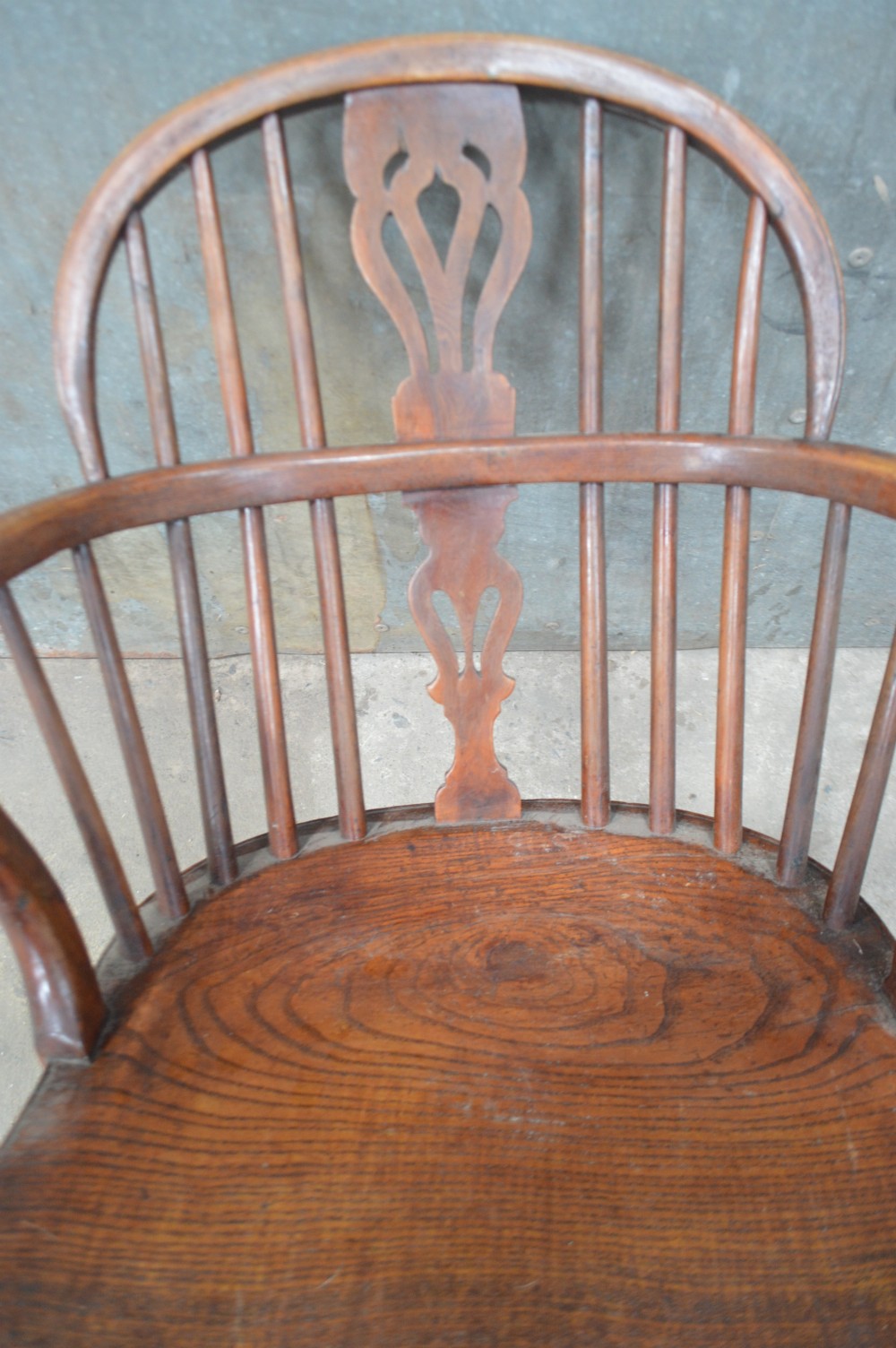 A Victorian low back Windsor armchair crafted from warm brown wood, featuring a bentwood arm bow, turned legs, and a decorative central pierced splat. View III