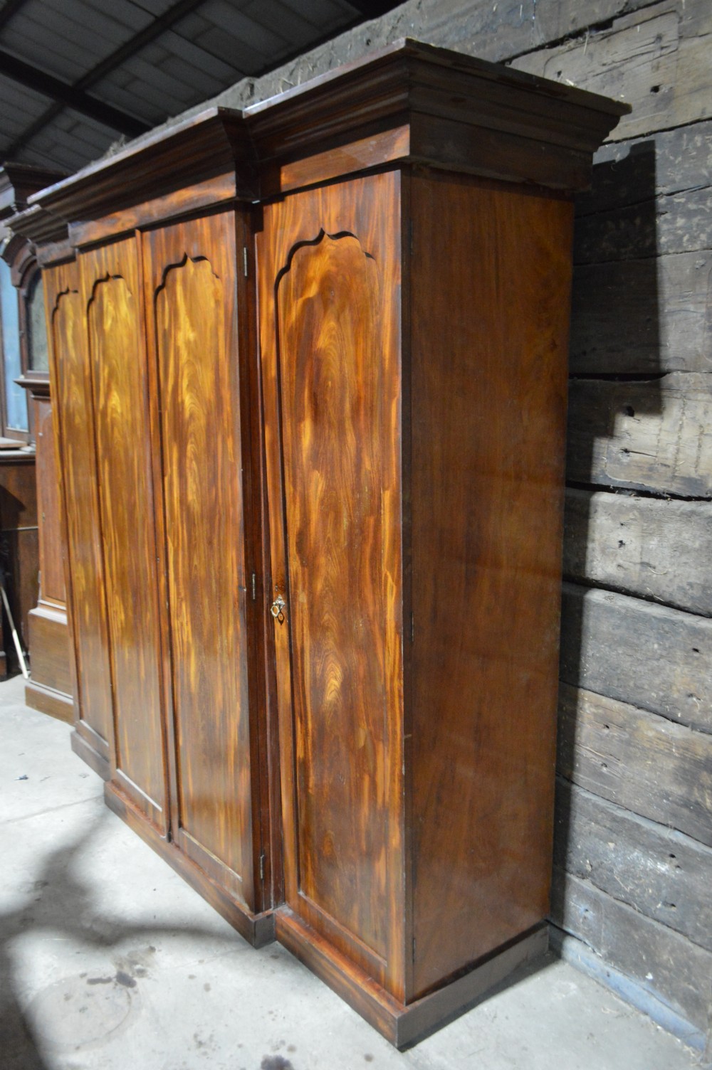 A nineteenth-century Victorian four-door breakfront wardrobe featuring flame mahogany panelled doors and a moulded top cornice. View II