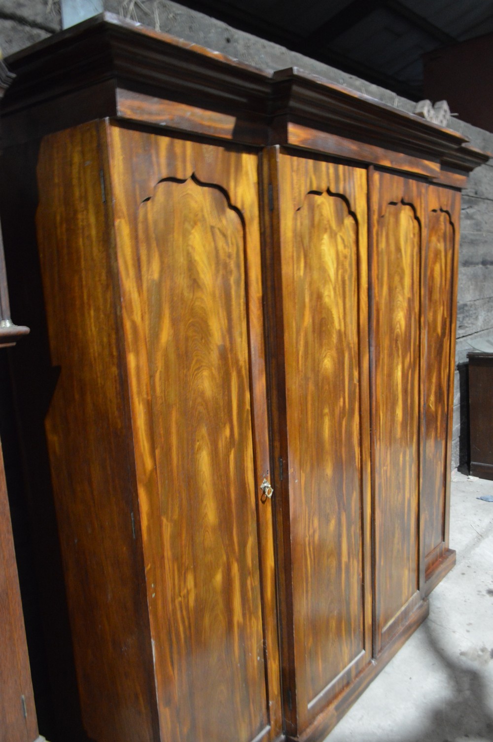 A nineteenth-century Victorian four-door breakfront wardrobe featuring flame mahogany panelled doors and a moulded top cornice. View X