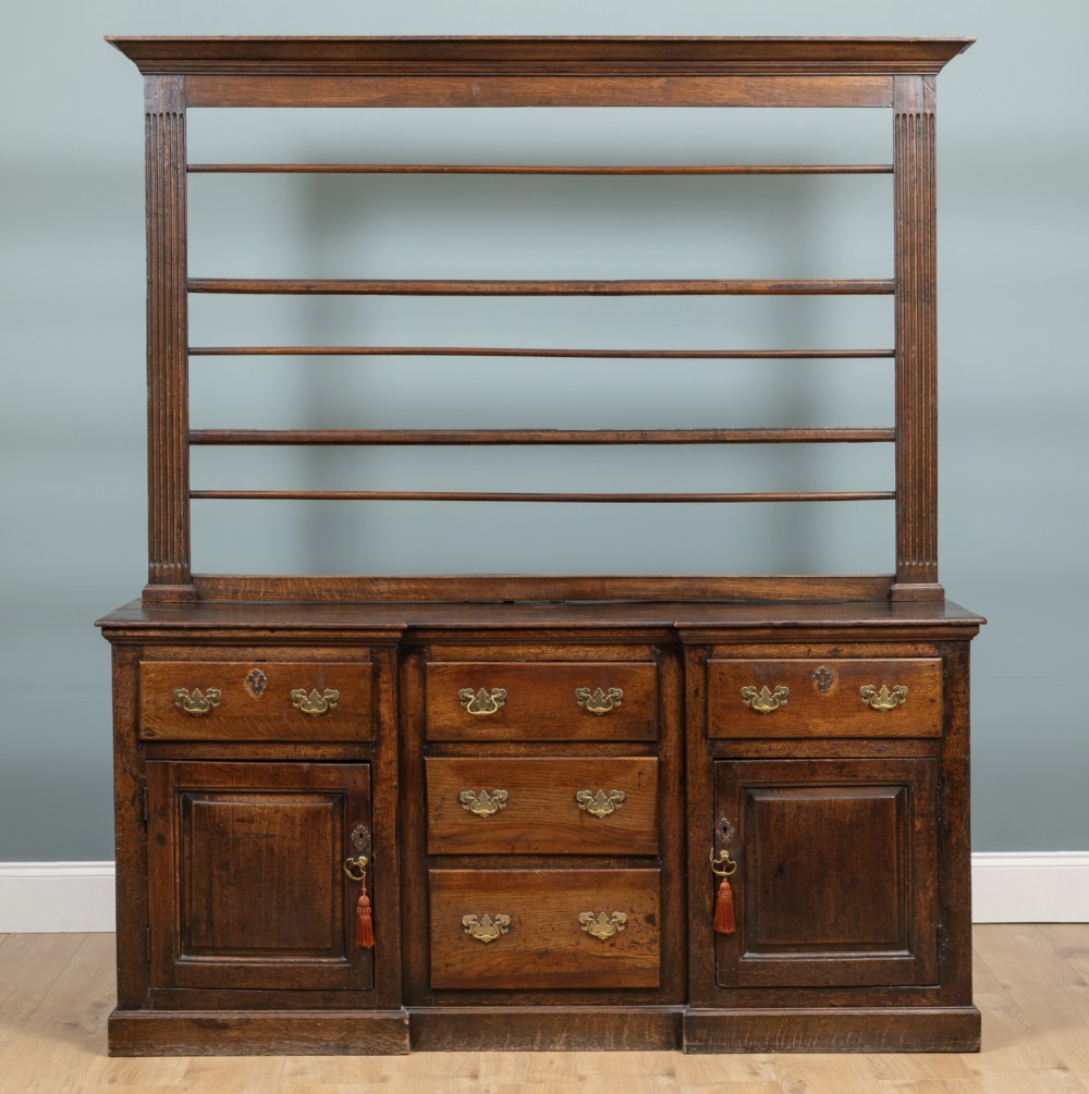 A George III oak, inverse breakfront, dresser.