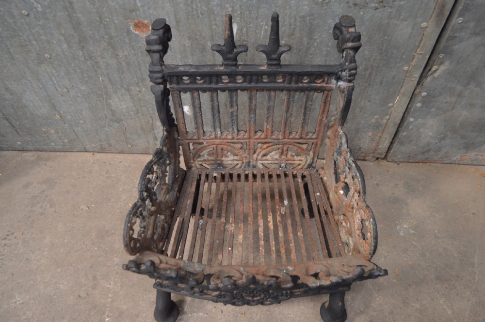 A heavy black cast iron fire basket featuring decorative Gothic style arches, finials, and an intricate fretwork front panel. View II