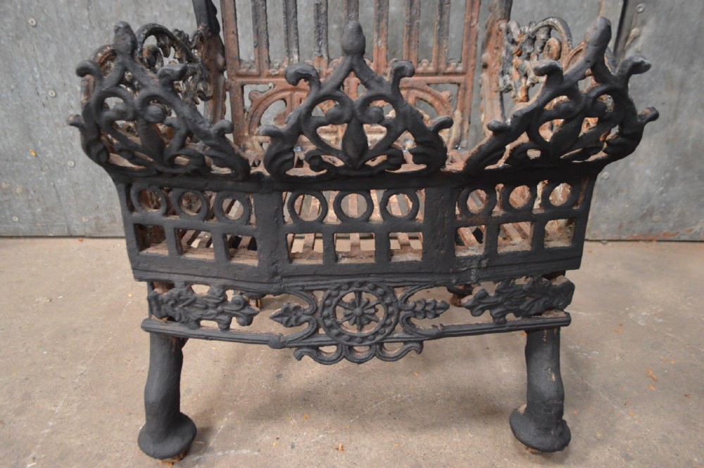 A heavy black cast iron fire basket featuring decorative Gothic style arches, finials, and an intricate fretwork front panel. View IV