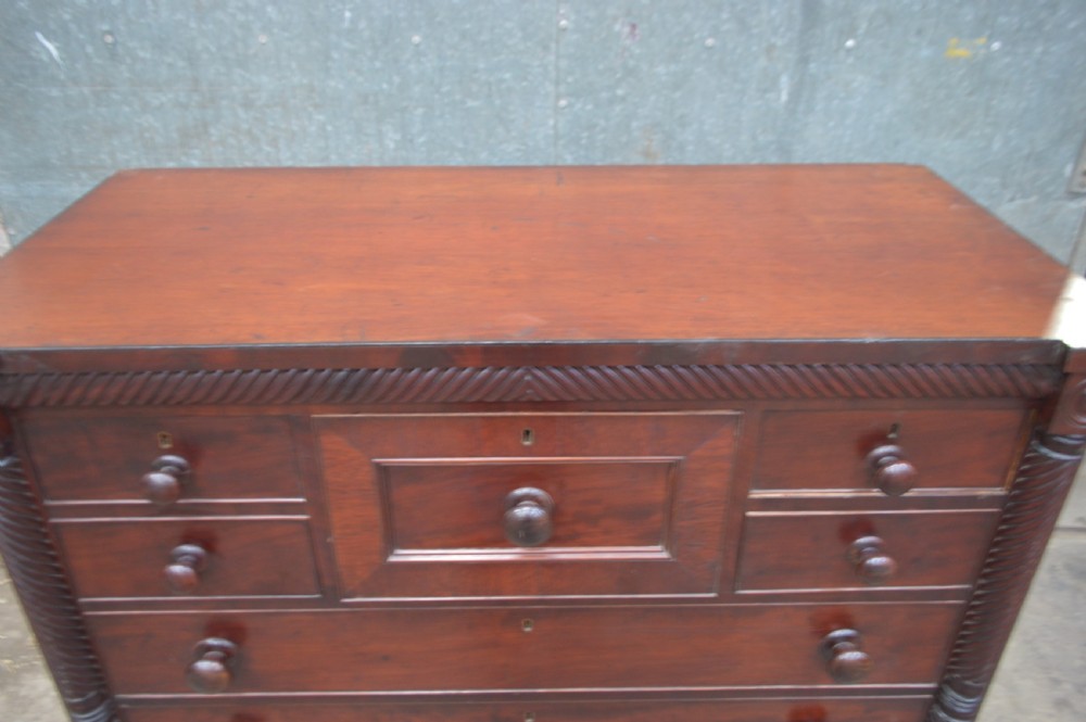 A Scottish Regency mahogany chest of drawers featuring rope-twist columns, corner rosettes, a central bonnet drawer, and turned feet. View II