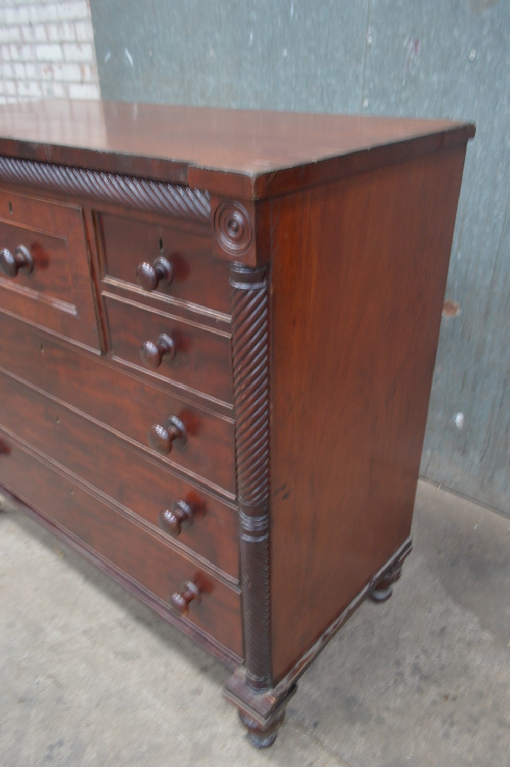 A Scottish Regency mahogany chest of drawers featuring rope-twist columns, corner rosettes, a central bonnet drawer, and turned feet. View III