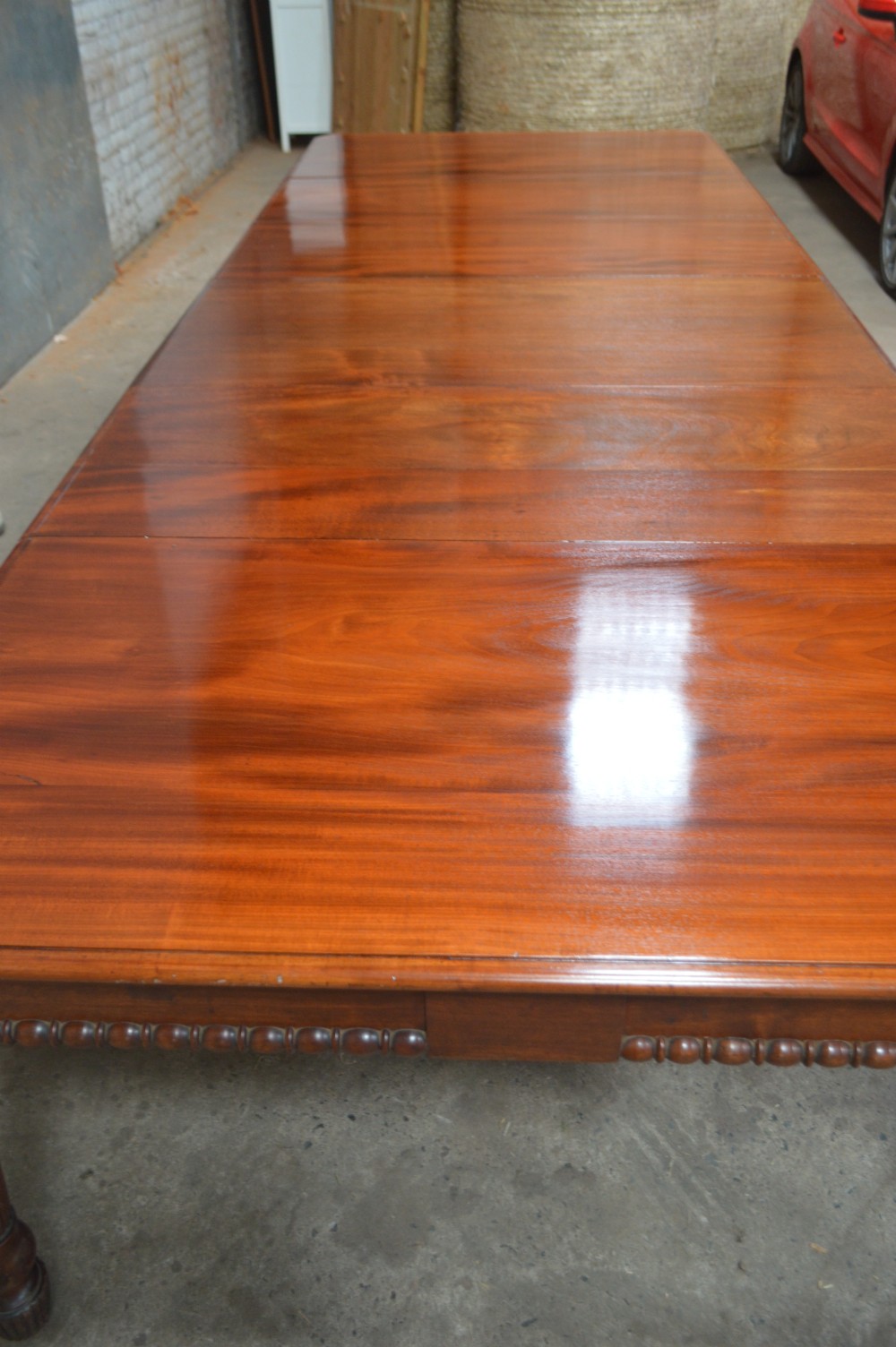 A long late Regency mahogany extending dining table featuring reeded turned legs on brass castors. View II