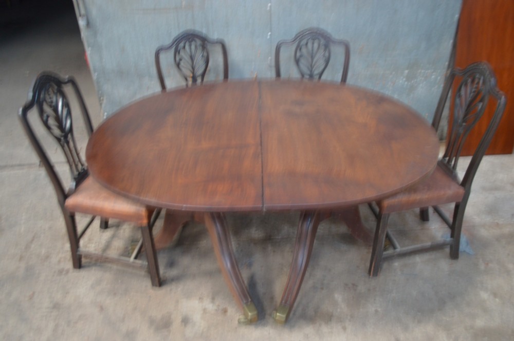 A dark mahogany George III pedestal dining table with double D ends and brass castors. View VI