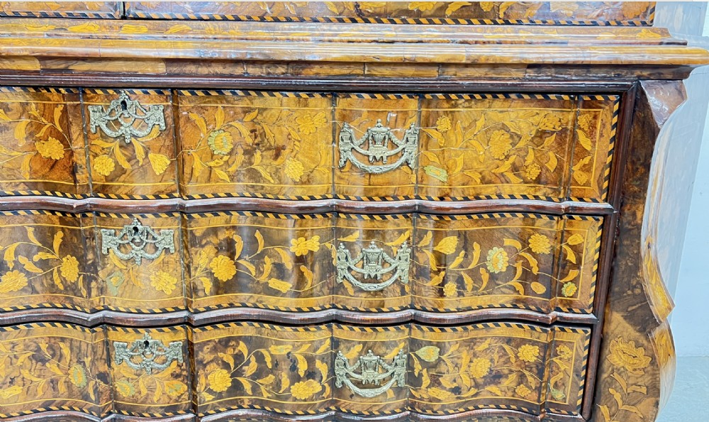 A Dutch walnut display cabinet featuring intricate floral marquetry inlay throughout, an arched glazed upper section, a shaped lower chest with drawers, and carved claw feet. View XI