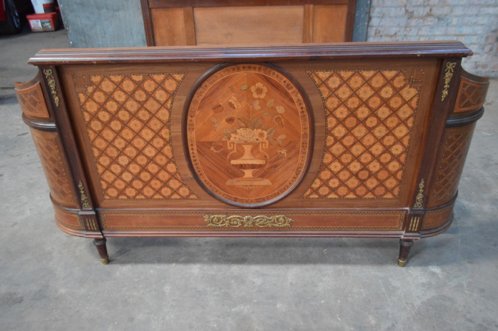 A French Louis XVI Revival wooden double bed featuring intricate floral marquetry paneling, trellis parquetry, curved footboard ends, and gilded metal mounts. View VII