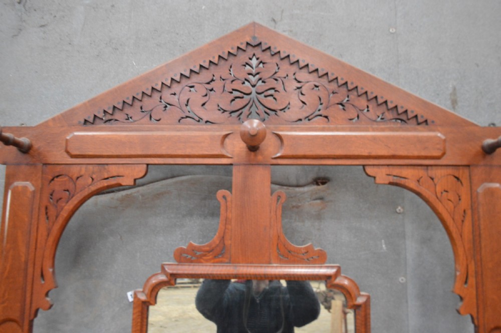 A Victorian oak hall stand featuring a central mirror, carved top pediment, coat pegs, a white marble console surface, and a lower shelf with umbrella drip trays. View III