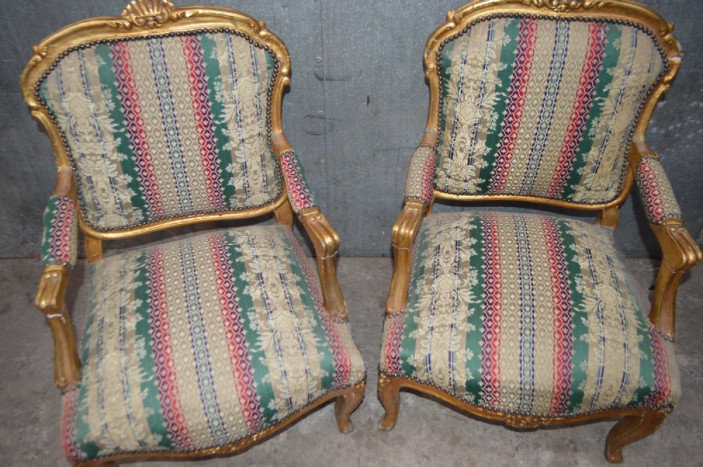 A pair of 19th-century French giltwood salon armchairs featuring carved crests, cabriole legs, and striped botanical woven fabric. View II