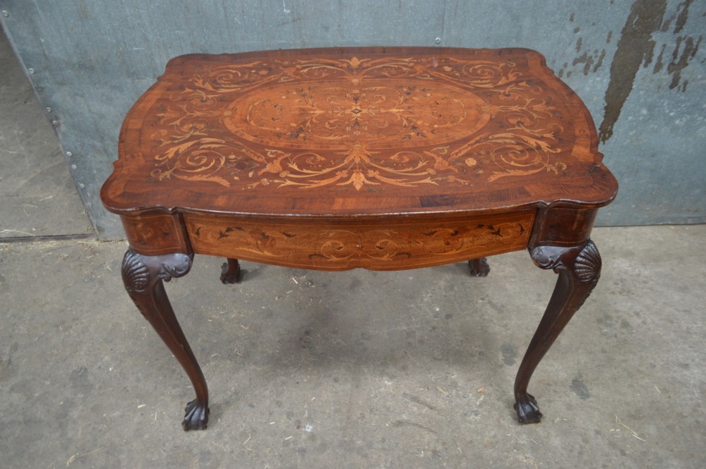 An 18th-century Dutch side table featuring floral marquetry inlay across a serpentine top, supported by cabriole legs with shell-carved knees and claw-and-ball feet.