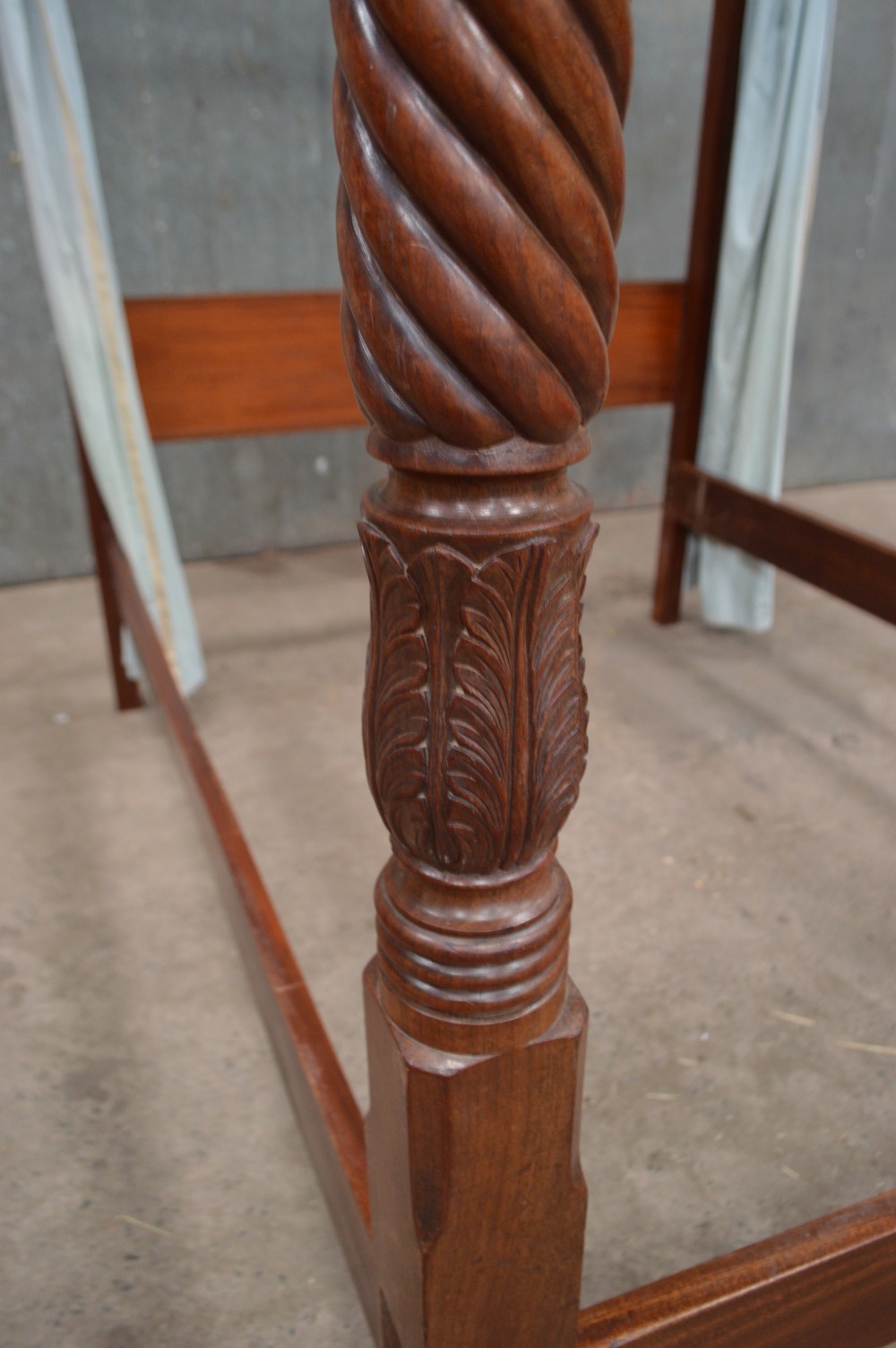 A Victorian mahogany four-poster bed featuring spiral barley-twist carved posts, a plain wooden headboard, and pale blue fabric drapery around the top frame. View II