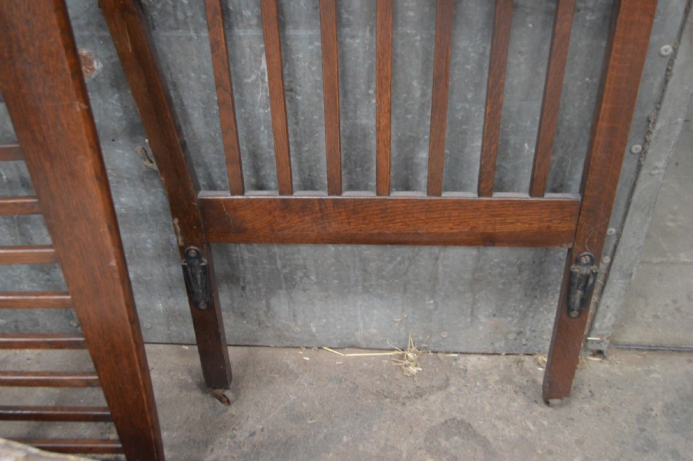 A 1920s oak day bed with vertical slatted back and side panels, fitted with a patterned floral cushion mattress. View V