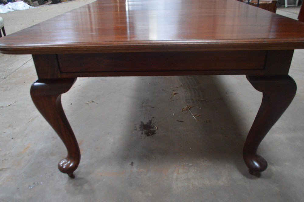 A large Victorian mahogany extending dining table with cabriole legs resting on castors. View II
