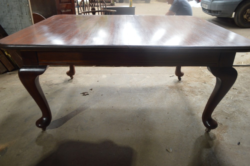 A large Victorian mahogany extending dining table with cabriole legs resting on castors. View VII