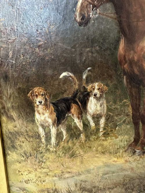 fig 1. An oil painting depicting a mounted huntsman in a red jacket accompanied by foxhounds, set within an ornate gilded frame.