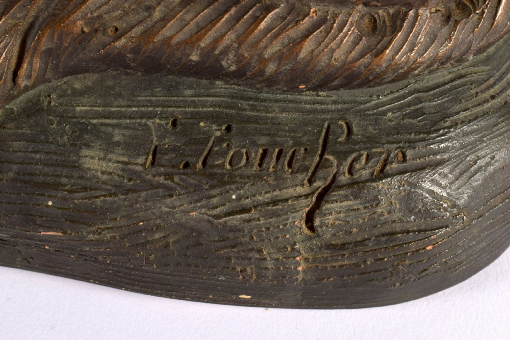 A patinated dark brown terracotta sculpture depicting a seated Alsatian dog on an integral naturalist base, signed by Foucher. View V