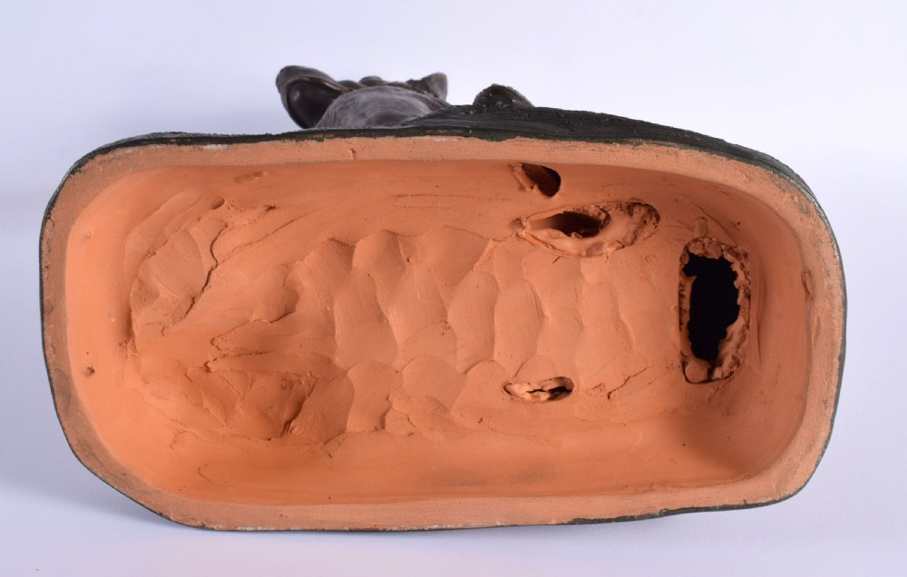 A patinated dark brown terracotta sculpture depicting a seated Alsatian dog on an integral naturalist base, signed by Foucher. View VII