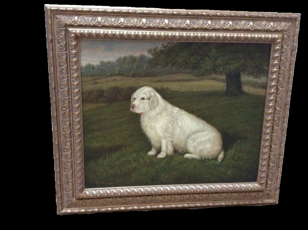 An antique oil painting depicting a white Clumber spaniel seated in a green grassy landscape, framed in a carved gilt frame. View II