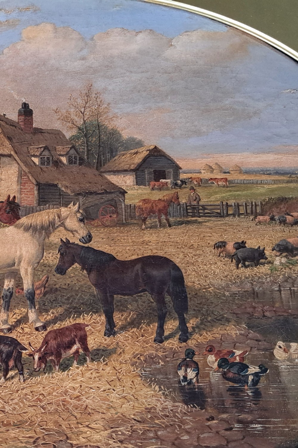 A 19th-century oil painting depicting horses and farmyard animals in a circular aperture, enclosed within a large square carved gilt frame. View V