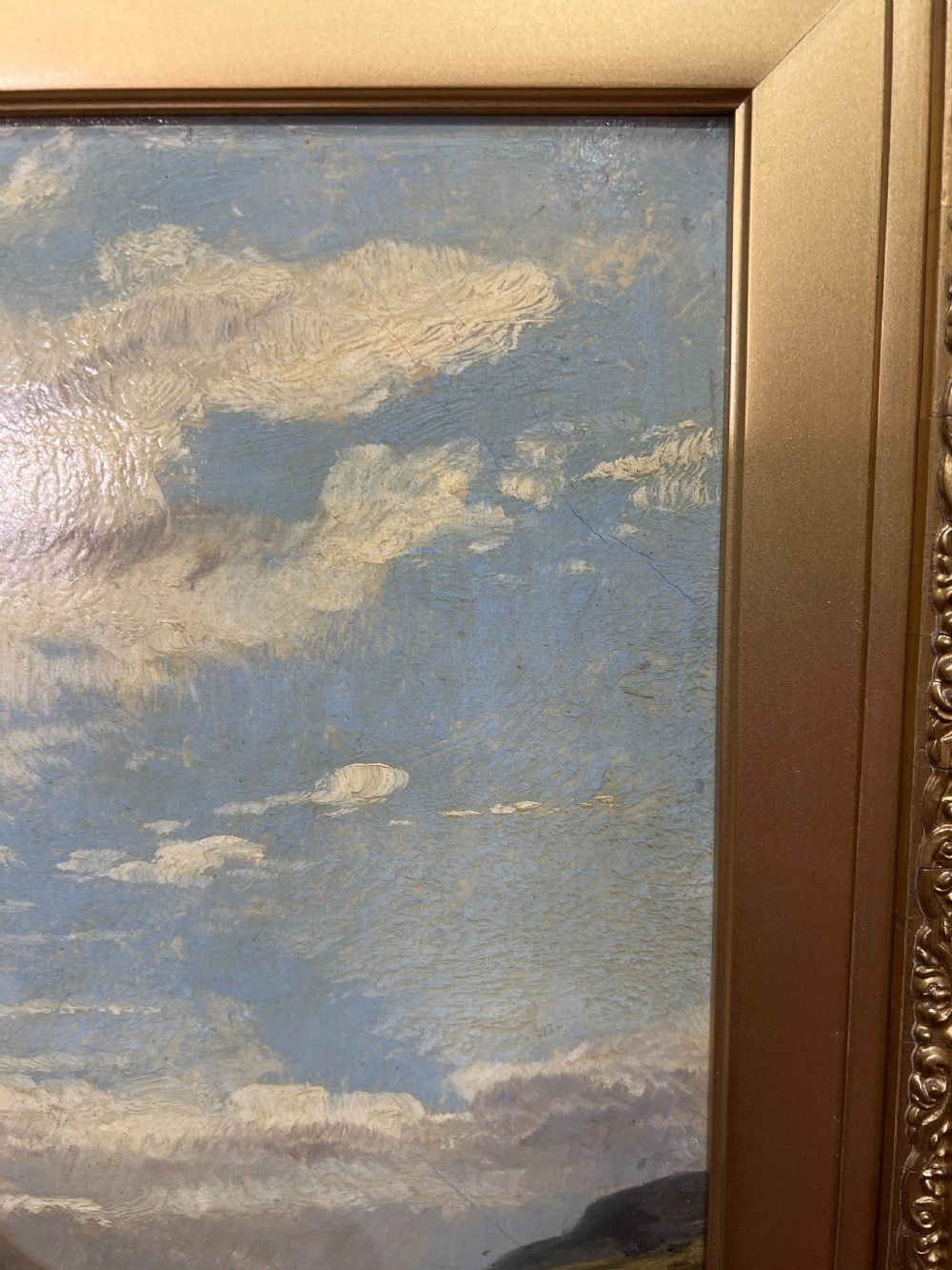 An oil painting depicting sheep grazing in a green valley before mountains, framed in an ornate gilded frame. View II