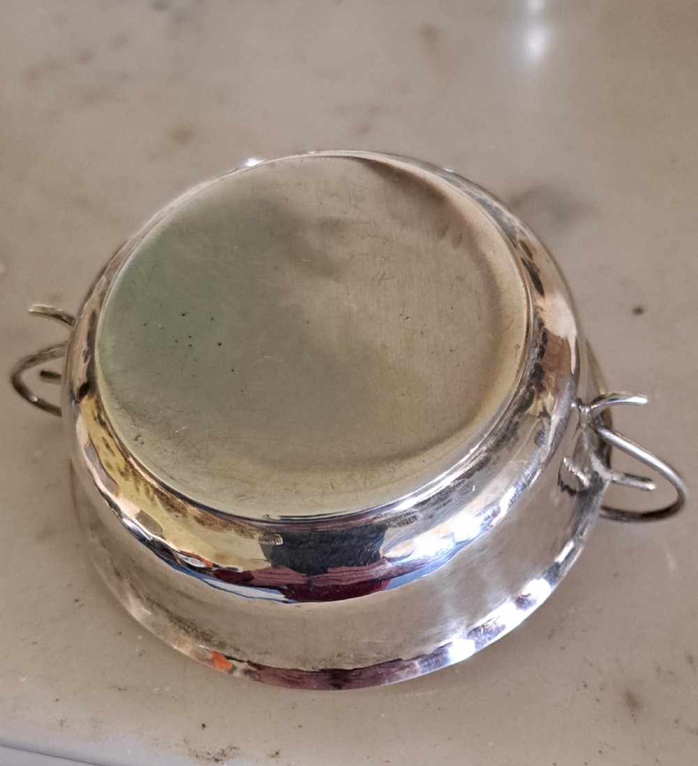 A set of four small, round sterling silver wine tasters with twin loop handles and visible hallmarks stamped on the polished interiors. View V