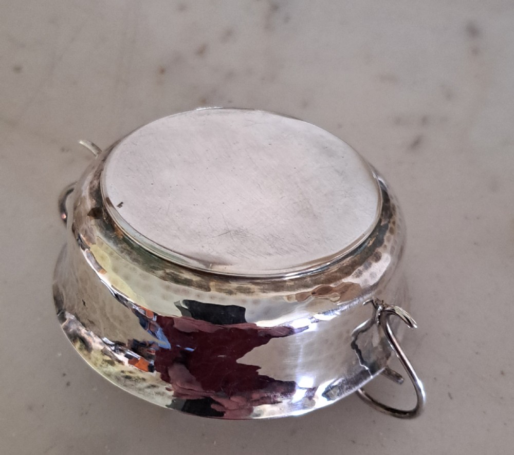 A set of four small, round sterling silver wine tasters with twin loop handles and visible hallmarks stamped on the polished interiors. View VI