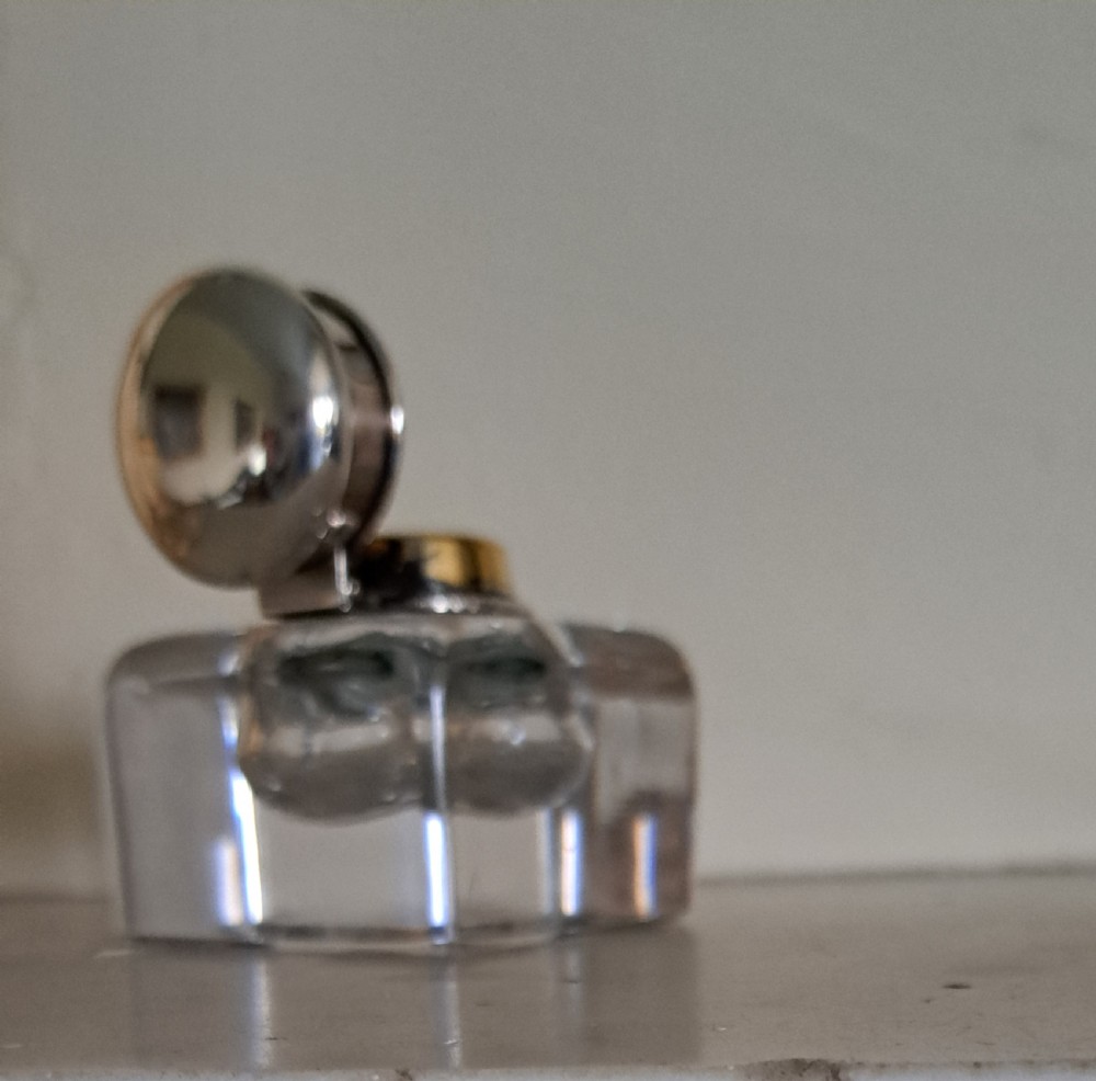 A square clear glass inkwell featuring a hinged silver dome lid with a gilded interior mechanism. View IV