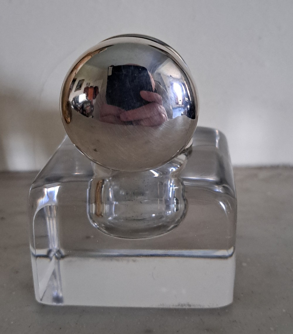A square clear glass inkwell featuring a hinged silver dome lid with a gilded interior mechanism. View VI