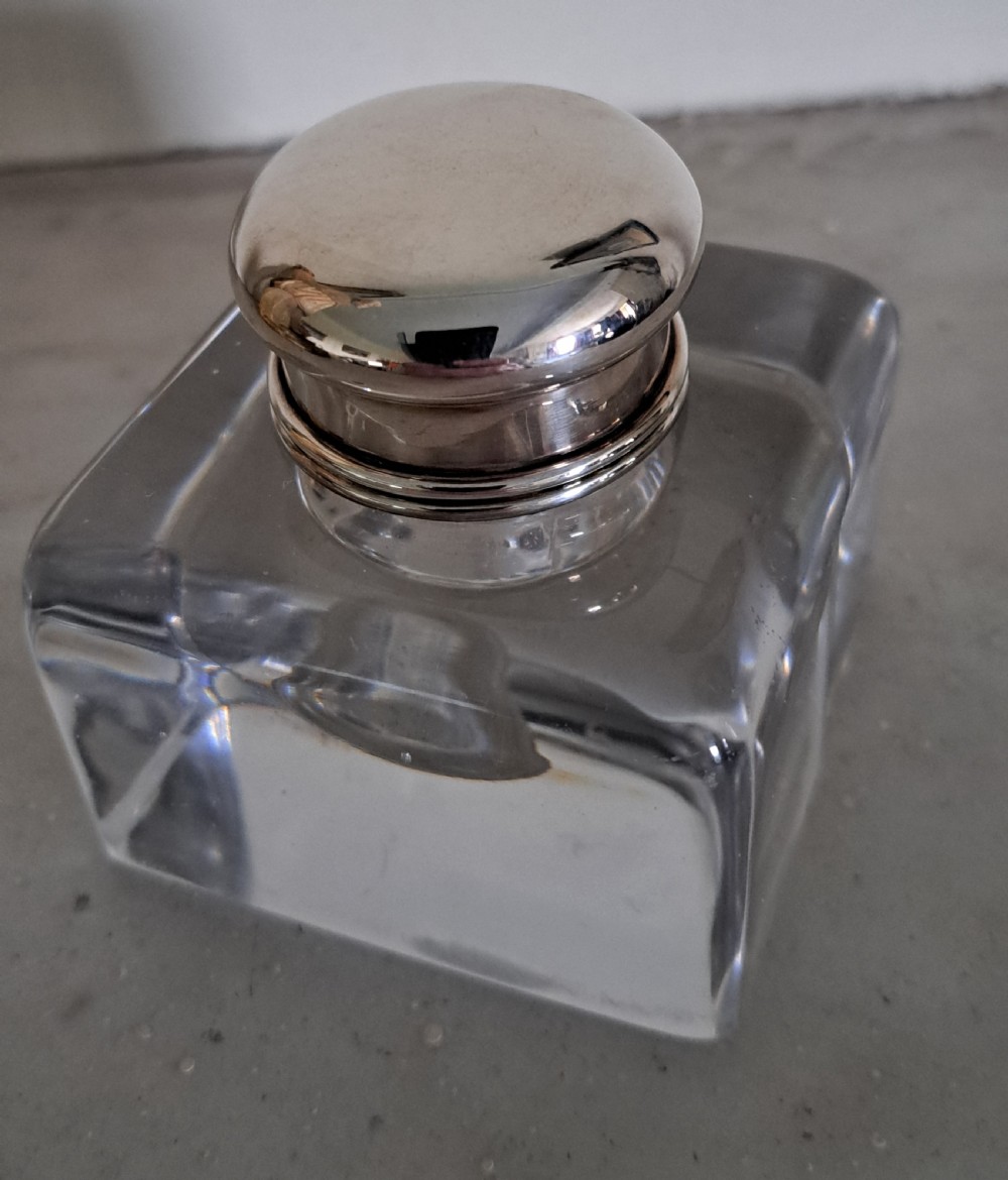 A square clear glass inkwell featuring a hinged silver dome lid with a gilded interior mechanism. View IX