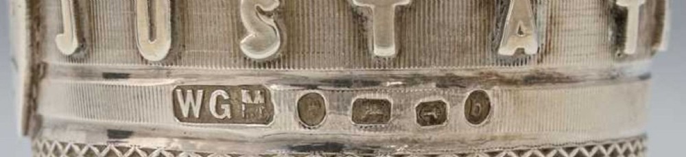 A Victorian sterling silver novelty spirit cup shaped as an oversized thimble with engine-turned texturing and raised lettering reading JUST A THIMBLEFUL, presented next to its plush-lined leather case. View VII