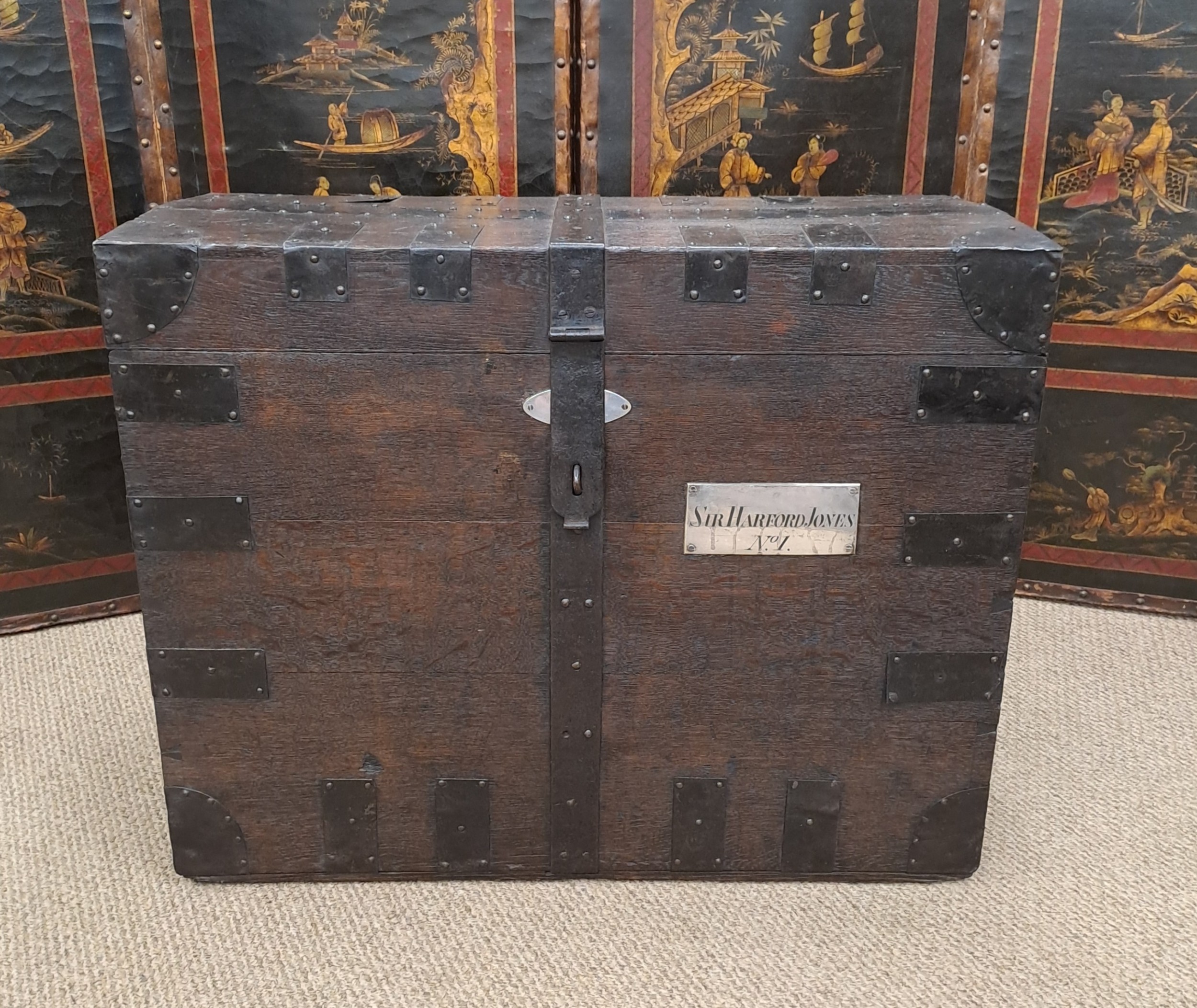 A dark Georgian oak silver chest bound with heavy iron strapwork and featuring an engraved metal nameplate on the front panel.