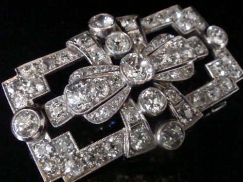 fig 1. An Art Deco platinum brooch set with old cut diamonds featuring a central bow motif within a rectangular geometric frame.