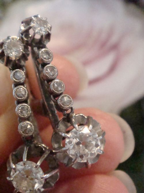 fig 1. A pair of French Edwardian platinum and diamond drop earrings featuring transitional cut diamonds suspended in articulated settings.