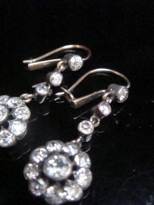fig 1. A pair of Edwardian silver and gold drop earrings featuring articulated strands of old cut diamonds leading to floral cluster drops.