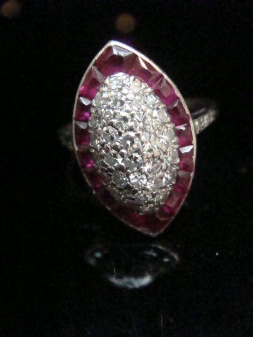fig 1. An Art Deco marquise cluster ring featuring a central diamond pave setting surrounded by a border of calibre-cut red rubies.